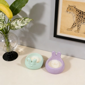 Detailed view of rabbit shaped mint green and lilac purple scented candle jars for Easter