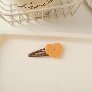 Detailed view of heart-shaped biscuit hair clip with a smooth brown metal snap pin