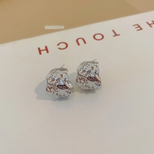 Detailed shot of silver stud earrings with unique irregular textured lava metal design