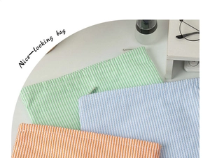 Flat seersucker striped toiletry bags in green blue and orange with metal zippers