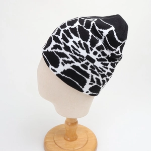 Close-up of the spider web jacquard pattern on a black and white knitted beanie