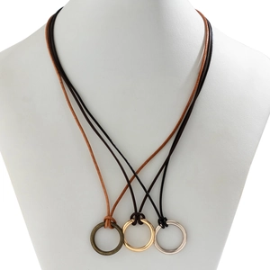 Vue macro de trois colliers en cordon de cire avec anneaux en bronze, or et argent