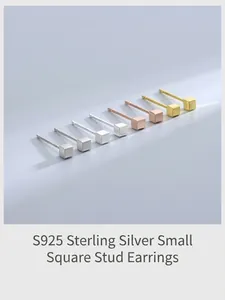 Detalle de pendientes geométricos de cubo en acabados plata, oro y oro rosa