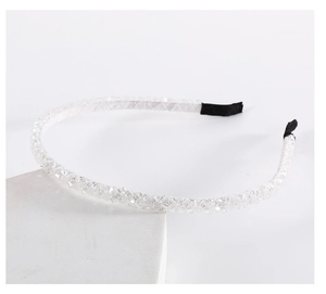 Close-up of double-row crystal beaded headband on a white stone background