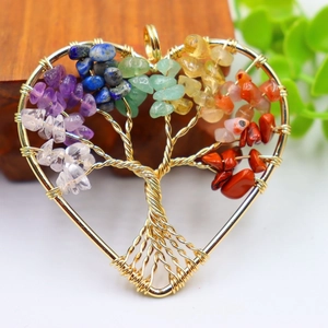Macro detail of heart-shaped wire wrapped tree of life pendant with colorful chakra stones