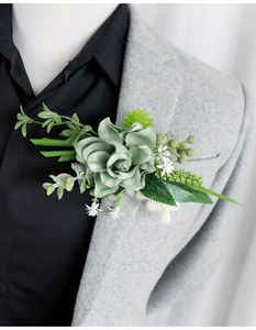 Detailed view of sage green succulent boutonniere on grey wool suit lapel for wedding events