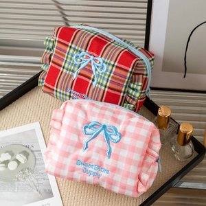 Cute plaid makeup bag with bow embroidery and ruffled edges in a cozy aesthetic setting