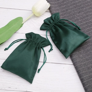 Dark green velvet drawstring pouch for jewelry gift packaging shown with tulip accents