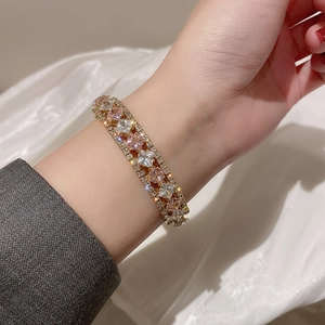 Detail of elegant gold bracelet featuring double rows of pink and clear zircon crystals