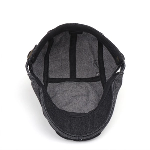 Detail of 100% cotton inner lining and adjustable metal buckle on grey denim beret