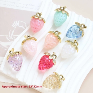 Macro view of 23x32mm acrylic strawberry pendants with metallic loops and textured surface