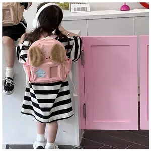 Detail of pink child backpack with cute dog ears and blue star patch on back