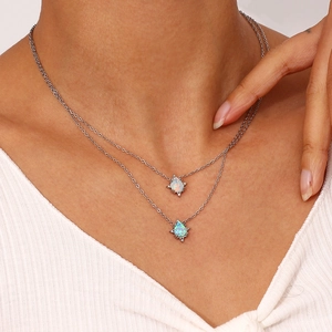 Close-up detail of double layer stainless steel necklace with drop opal pendants for women.