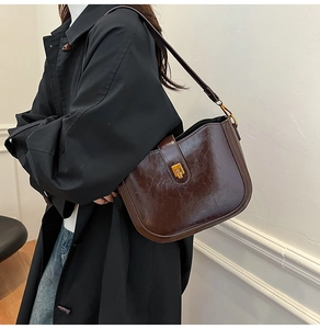 Detail of vintage dark brown faux leather saddle bag with polished oil-wax texture