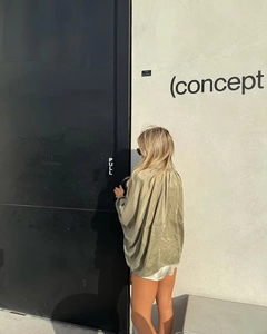 Street style view of olive green satin bomber jacket with loose back silhouette and high shine