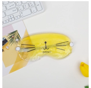 Macro shot of yellow cat gel eye mask with meow prints on a desk with tulips