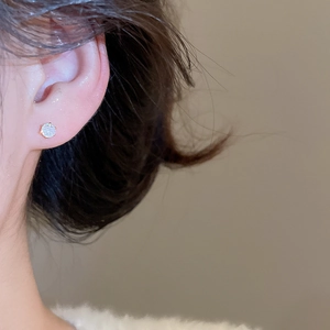 Detailed macro view of gold-plated silver round zircon stud earrings for women