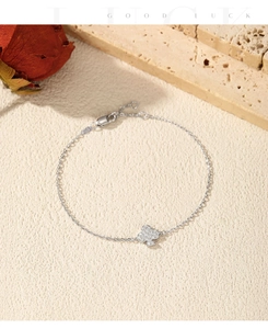 Detailed view of silver adjustable bracelet with sparkling clover pendant and gemstones