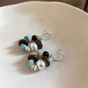 Detail of bohemian star charm earrings with colorful turquoise and wooden beads