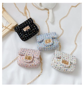 Flat lay of four mini tweed crossbody bags in black blue pink and cream colors with chains