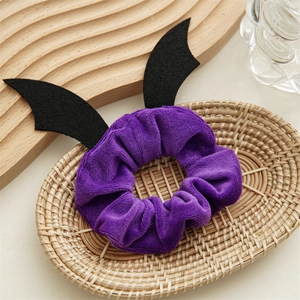 Chouchou Halloween en velours violet avec ailes de chauve-souris noires dans un panier