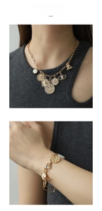 Detailed view of gold celestial necklace and bracelet set with sun and moon charms