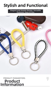 Dettaglio di portachiavi in pelle intrecciata con anelli metallici lucidi in vari colori