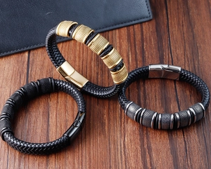 Close-up of braided leather bracelets with textured gold, silver, and black metal magnetic clasps
