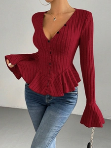 Detail of wine red knit cardigan featuring V-neckline, ruffles and ribbed texture