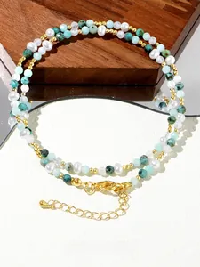 Detail of bohemian layered necklace with turquoise stones, pearls and golden lobster clasp