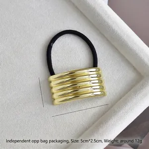 Macro detail of U-shaped gold alloy hair ring with dimensions 5cm x 2.5cm on white velvet