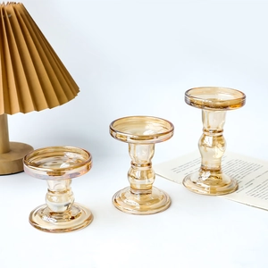 Three amber glass Roman pillar candle holders in various heights for dining table decor