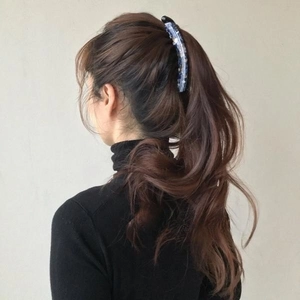 Dark blue glitter banana clip securing a high ponytail on a model with brown hair