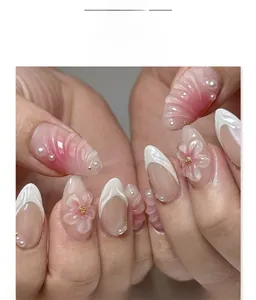 Close-up of pink gradient press-on nails with 3D floral accents and pearl details