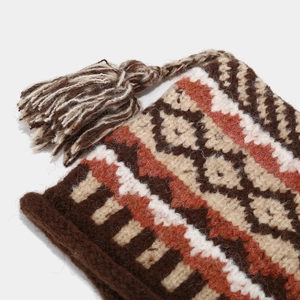 Close-up of geometric jacquard knit pattern and soft tassels on vintage knit hat