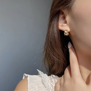 Minimalist gold irregular lava texture hoop earrings shown on a female model