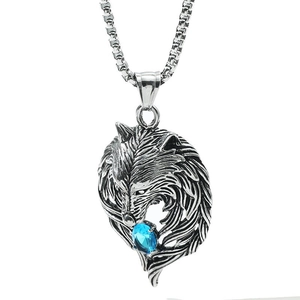 Detailed view of vintage silver wolf head pendant featuring a faceted blue gemstone inlay
