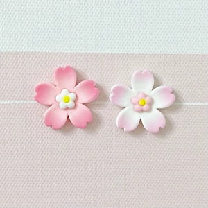 Detailed view of pink and white resin cherry blossom charms for DIY craft accessories