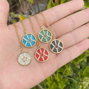 Detailed view of gold star necklaces with turquoise, malachite and zircon stones