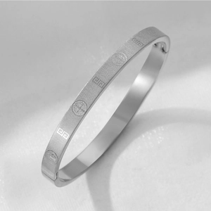 Detail of silver titanium steel bracelet featuring St. Benedict medals and mesh texture