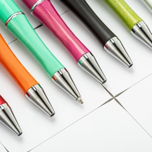 Colorful DIY plastic beadable ballpoint pens with silver metal tips on grid paper