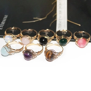 Detalle de anillos hechos a mano con alambre dorado y varias cuentas de cristal natural