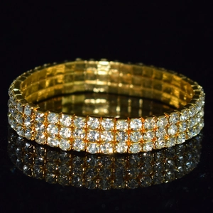 Detailed macro view of the three-row rhinestone crystal arrangement on a gold bridal bracelet