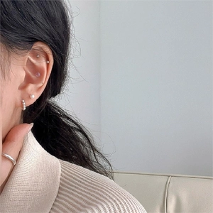 Detail of 925 sterling silver jewelry set featuring ball studs, hoops, and a minimalist ring