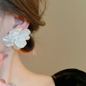 Elegant white acrylic flower earrings with pearl accent shown on a female model