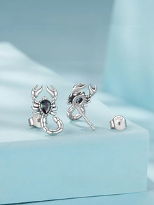 Detail of S925 sterling silver scorpion earrings with iridescent pear-shaped gemstone