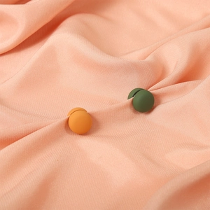 Magnetic macaron scarf buckles in orange and dark green with a matte finish