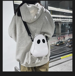 Girl wearing the white ghost crossbody bag in PU leather with black adjustable strap