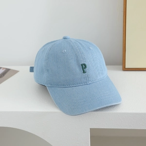 Detail of light blue denim kids baseball cap featuring green embroidered letter P
