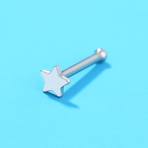 Macro view of silver stainless steel nose stud with a white star-shaped decorative top
